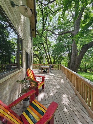 A wooden deck with outdoor furniture, a table, and chairs. - Family-Friendly Retreat on Julia Street - Explore Okoboji from Your Doorstep (Okoboji)