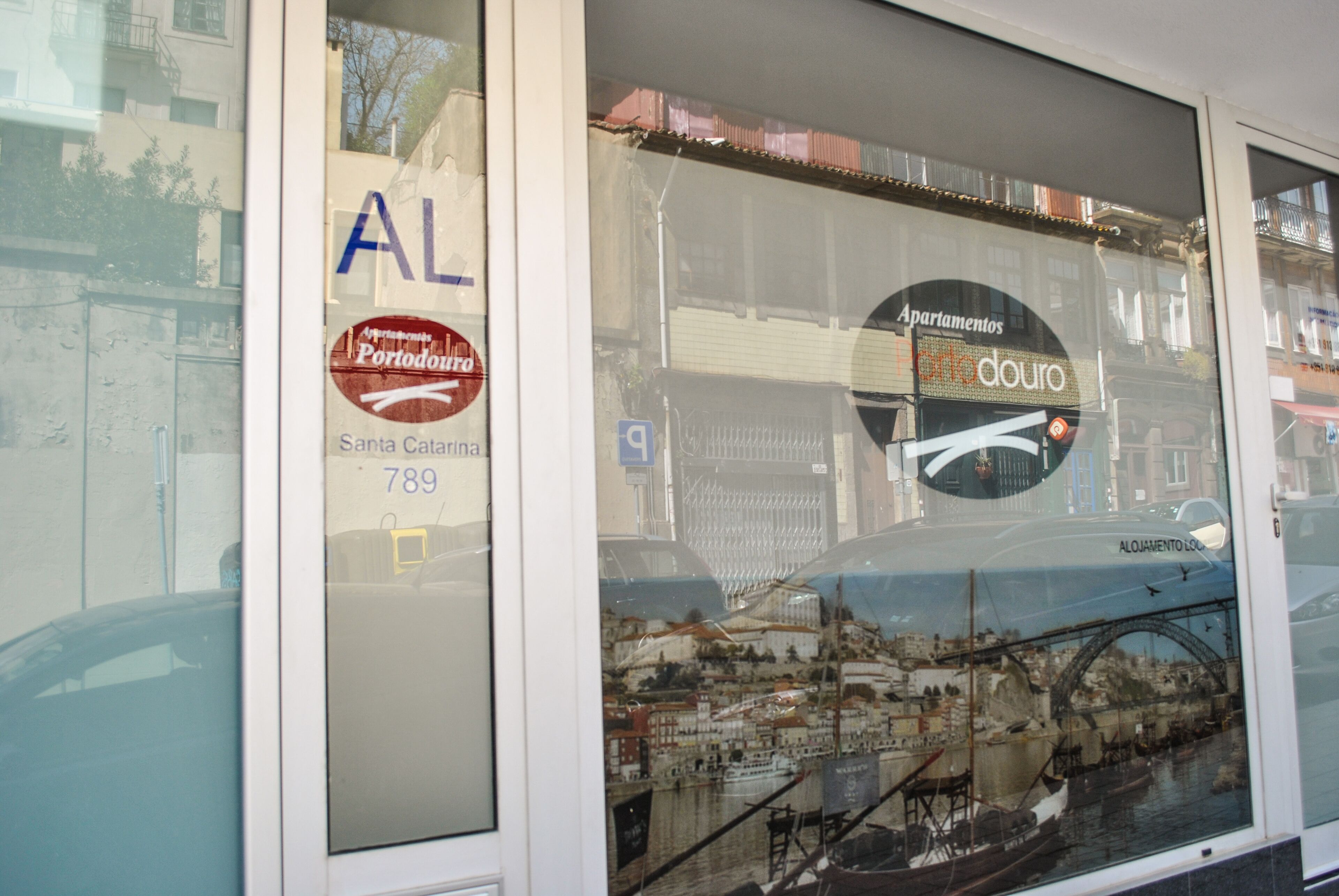 A window with a reflection of a cityscape, including a bridge and buildings.