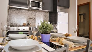 Une cuisine moderne avec des meubles de couleur sombre, un four à micro-ondes et un réfrigérateur.