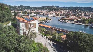 Un paysage urbain côtier avec une rivière, des bâtiments et une imposante structure blanche dotée de panneaux solaires.