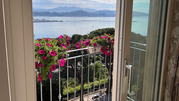 Een balkon met uitzicht op een meer en bergen.