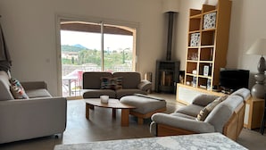 A living room with a fireplace, sofas, a coffee table, and a TV.