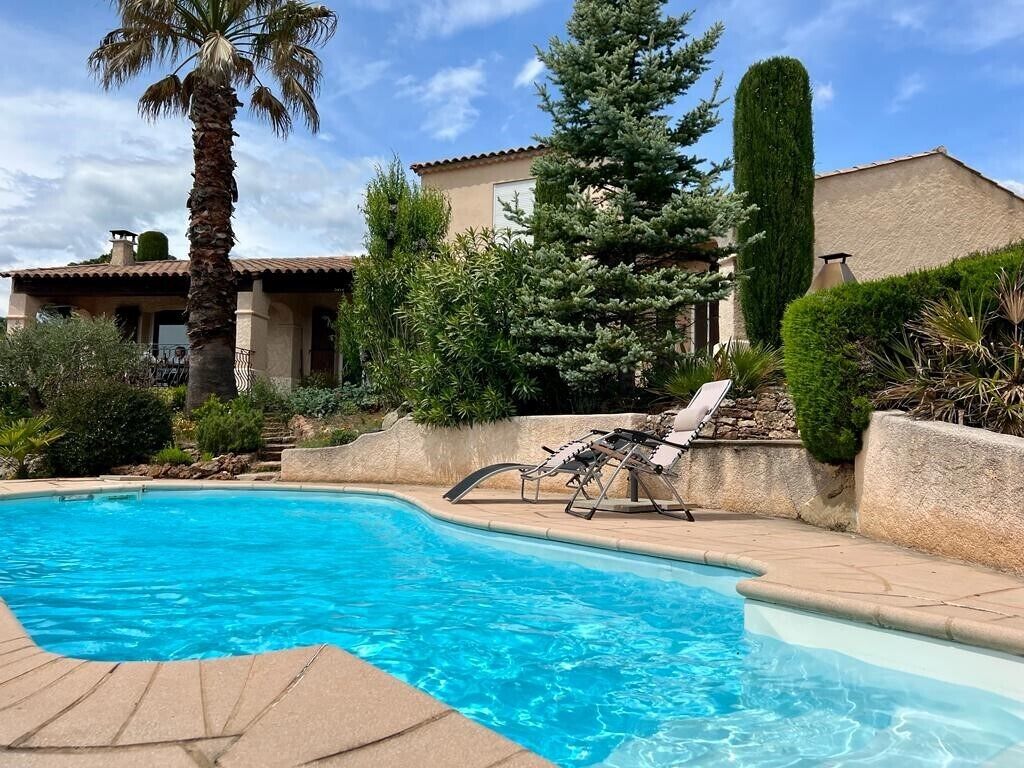 Una piscina con una palmera y una silla.