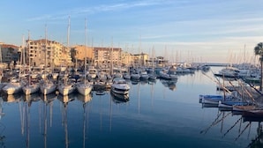A marina with numerous boats docked, surrounded by buildings.