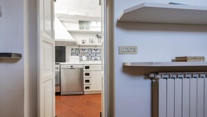 A kitchen with white cabinets, a built-in oven, and a tiled backsplash. - Italianway Comfort - Vigevano 7 (Milan)