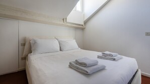 A bedroom with a bed, pillows, and folded towels. - Italianway Comfort - Vigevano 7 (Milan)