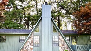 A house with a stone facade and a steeply pitched roof. - Doc's Cottage - A-Frame in Piggott, AR (Piggott)