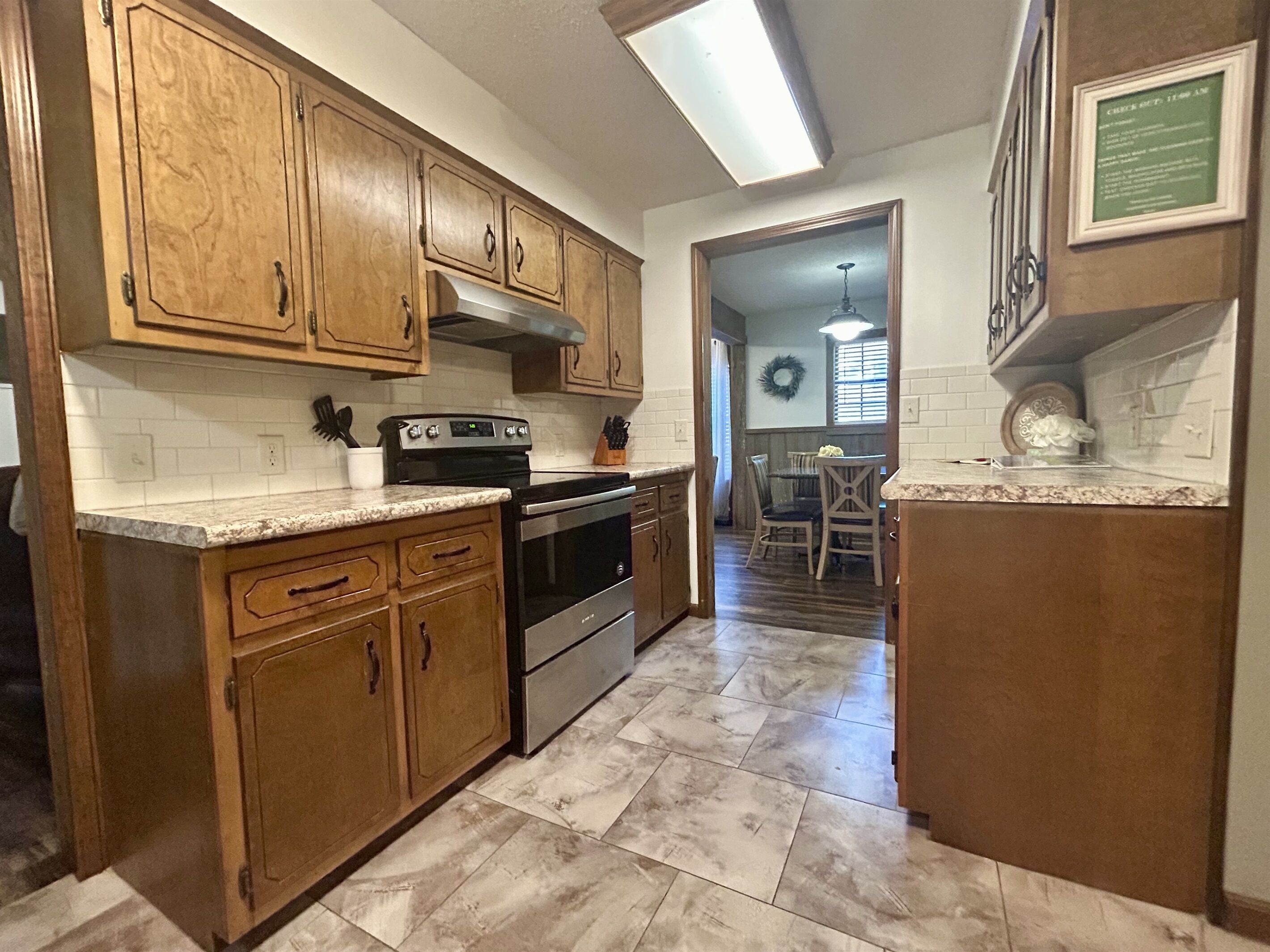 A kitchen with wooden cabinets, a built-in oven, and a granite countertop.