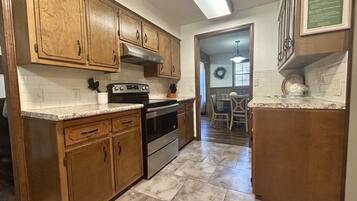 A kitchen with wooden cabinets, a built-in oven, and a granite countertop.