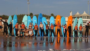 A group of people holding surfboards on a beach. - Lisbon Soul Surf Camp (Cascais)