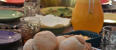 A dining table with various dishes, glasses, and a pitcher of orange juice.