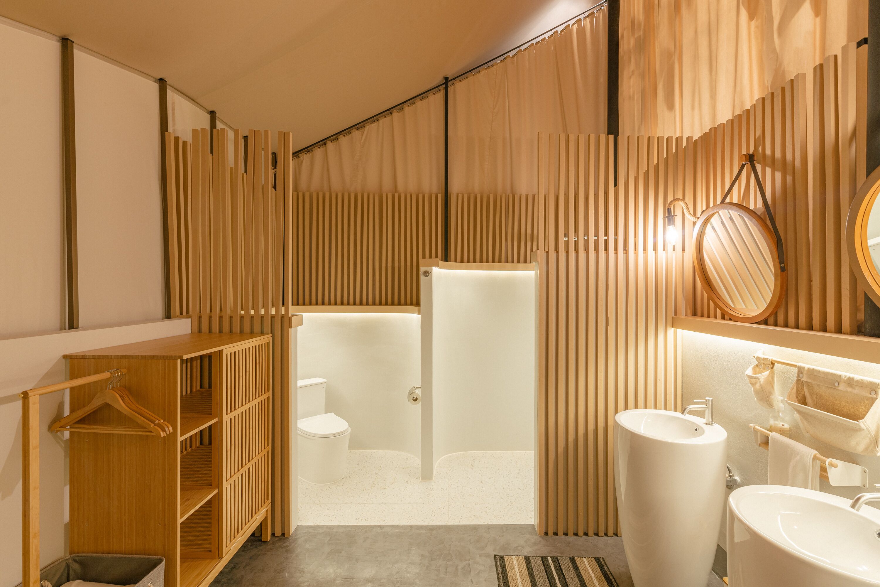 A modern bathroom with a wooden vanity, a large sink, and a shower area.