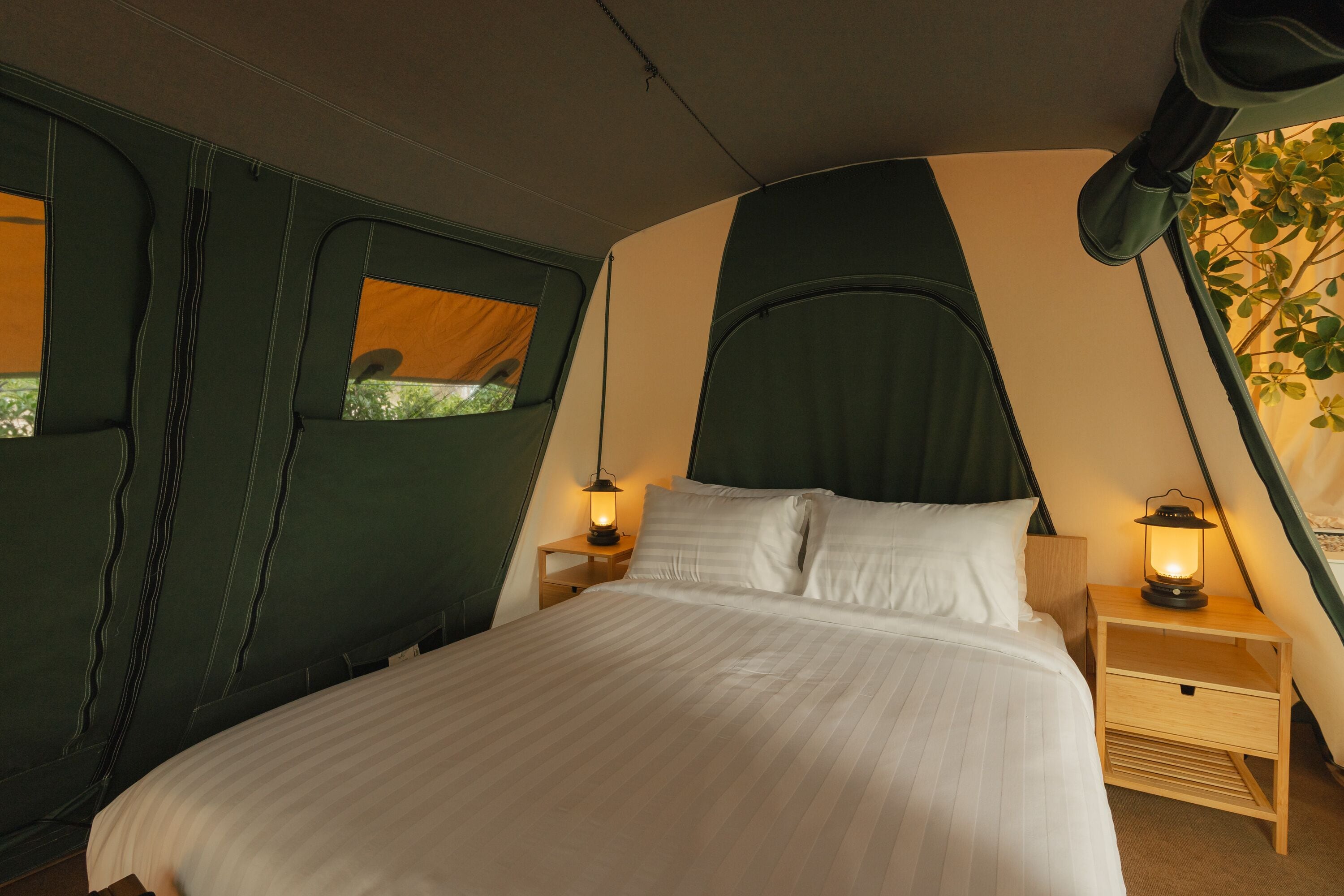 A bedroom with a bed, two bedside tables, and a window.