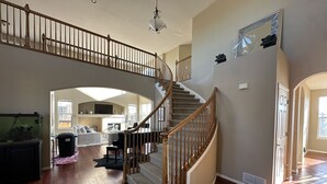 Un vaste espace de vie agrémenté d’un magnifique escalier, d’une cheminée et d’une grande fenêtre laissant entrer la lumière naturelle.