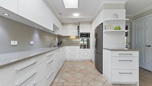 Eine moderne Küche mit weißen Schränken, einem eingebauten Backofen und einem Kühlschrank.
