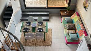 Un intérieur moderne comprenant un coin repas, un canapé et un escalier.