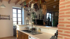 A kitchen with wooden cabinets, a white dishwasher, and a countertop with various kitchen utensils hanging above.