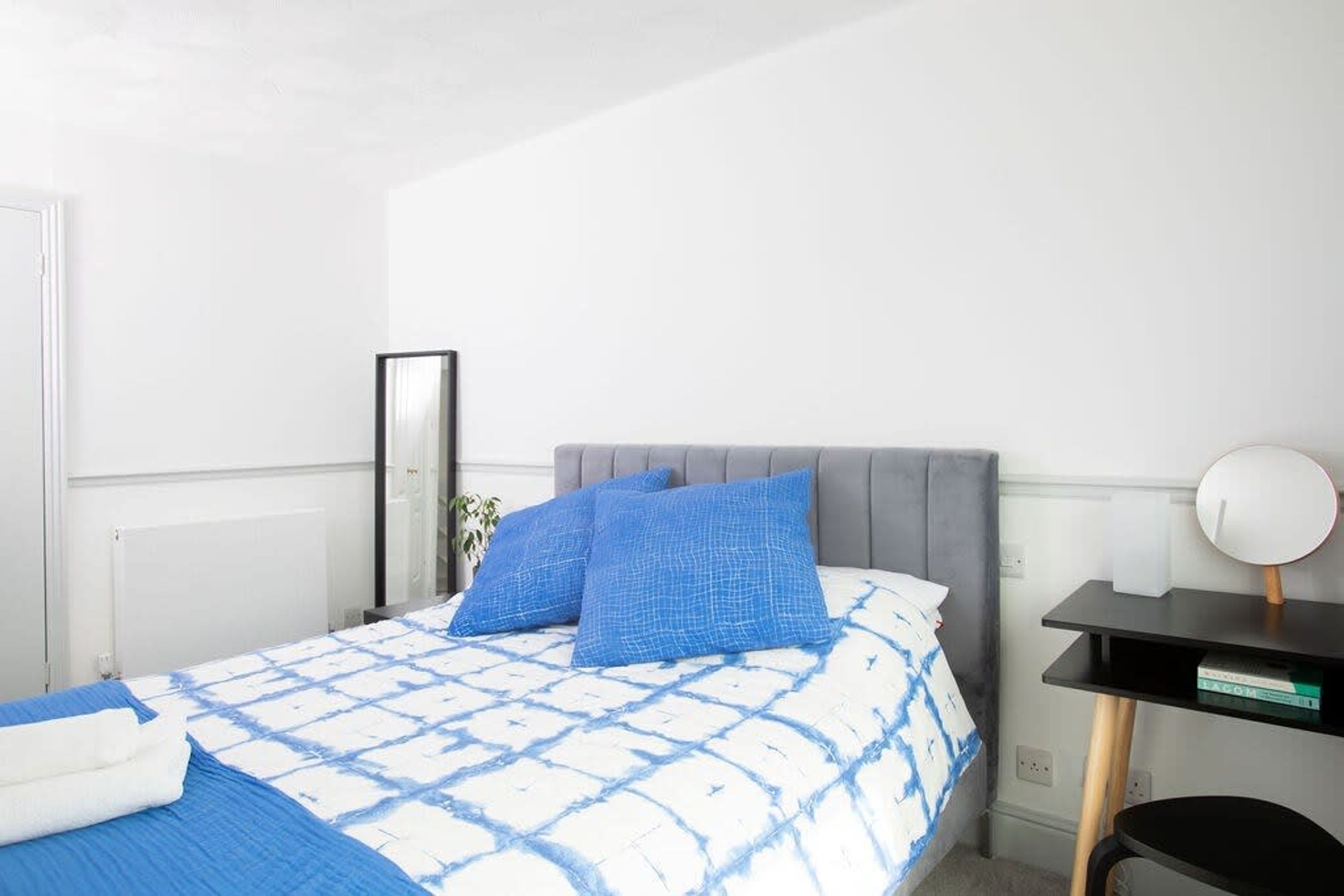 A neatly arranged bedroom with a bed, a bedside table, and a chair.