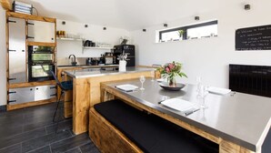 A modern kitchen with a central island, built-in appliances, and a chalkboard sign.