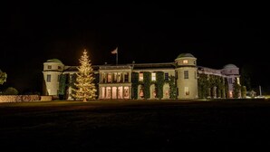 A large, illuminated building with a central dome, two smaller domes, and a flag. - Countryside Annexe Near Goodwood (Chichester)