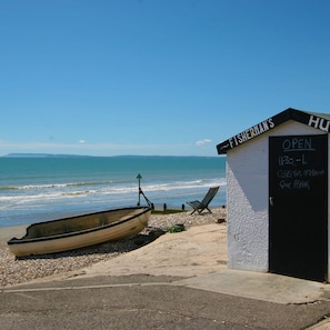 Ein Strandhütten mit der Aufschrift "FISHERMAN'S Hut" und einem Schild, das die öffnungszeiten von 11:30 bis 1:00 Uhr angibt.