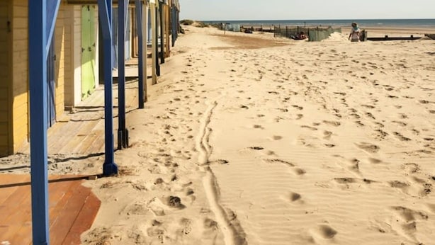 A row of beach huts with a sandy beach and the sea in the background. - Absolute Beachfront With Decked Garden Oasis and Views (Bognor Regis)