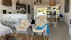 A spacious living area with a kitchen, dining table, and seating.