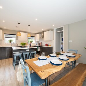 Enjoy meals at the central island breakfast bar in this modern kitchen with stainless steel appliances and white cabinetry.