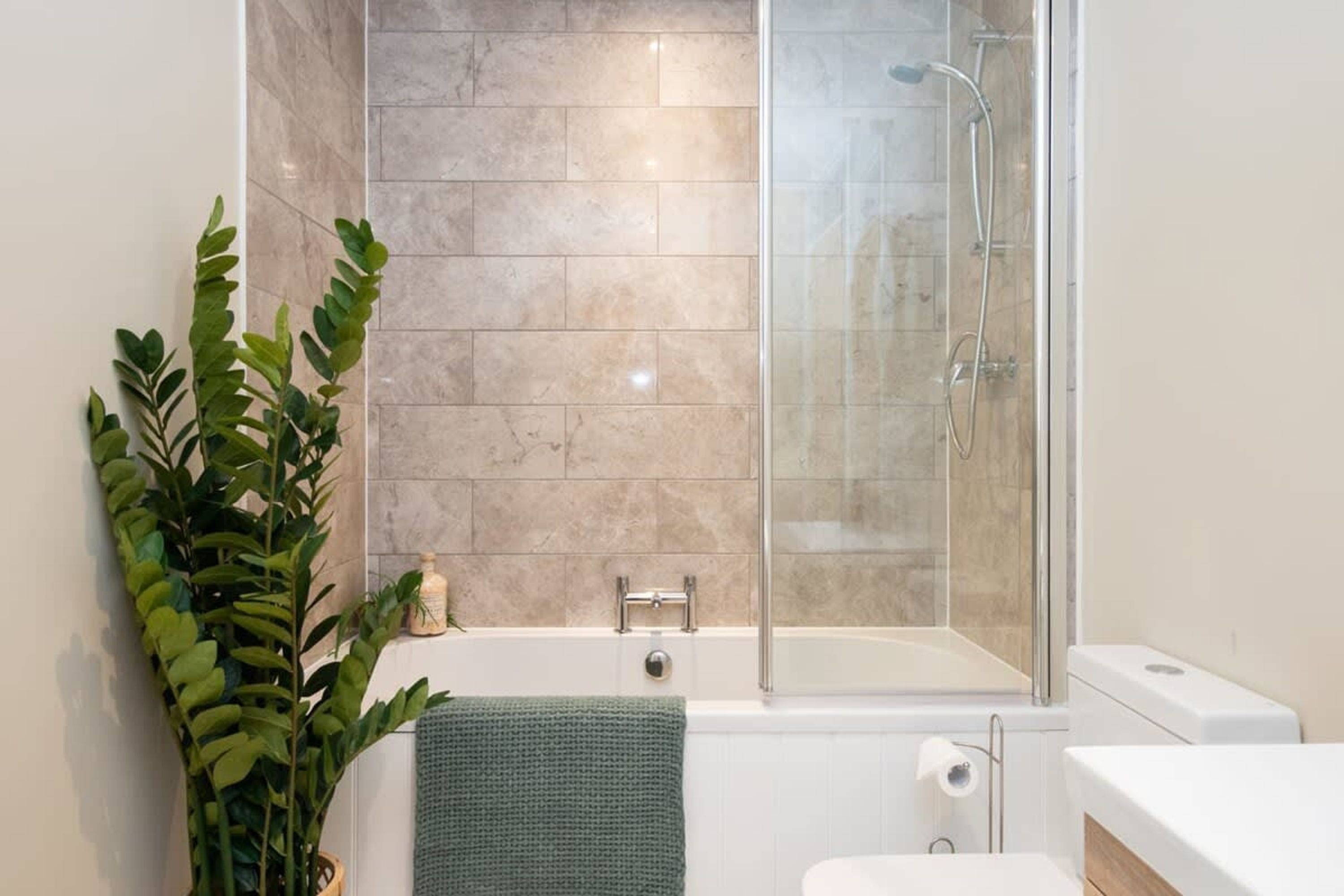 Un baño moderno con ducha acristalada, bañera y retrete.