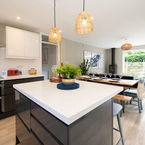 Enjoy meals in the spacious kitchen with a central island, dining area, and stove.