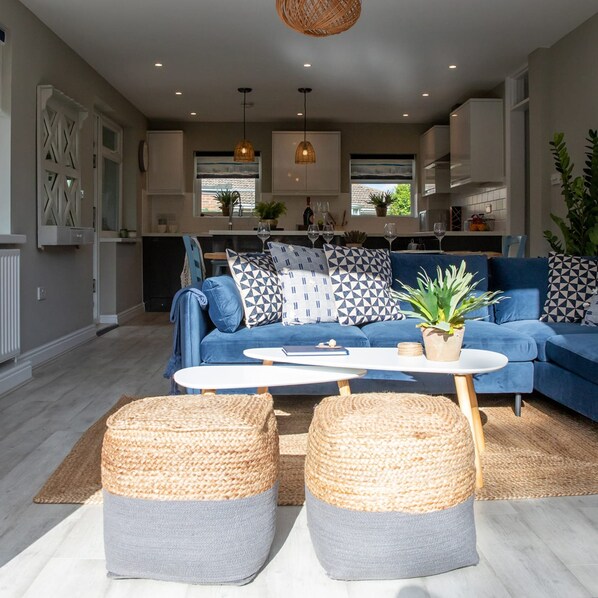 Relax in this stylish living space with a comfortable sofa, coffee table, and woven poufs.