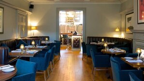 A restaurant with booths and tables, wooden flooring, and a central bar area. - Charming 3bd Townhouse Right in the City Centre (Chichester)