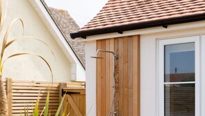 A wooden door with a showerhead, a window, and a wooden fence. - Mariners Stylish Beachside Getaway With Sea Views (Chichester)