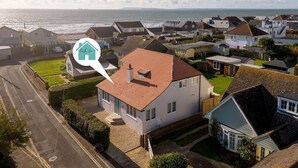 A residential area with houses, a road, and a view of the sea. - Mariners Stylish Beachside Getaway With Sea Views (Chichester)