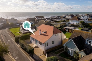 Un quartier résidentiel avec des maisons, une route et une vue sur la mer.