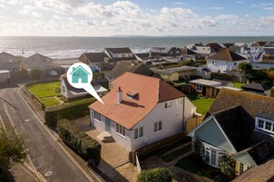 Un barrio residencial con casas, una carretera y vista al mar.