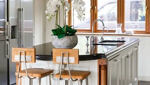 A kitchen with white cabinets, a stainless steel refrigerator, a granite countertop, and a large window with a view of the outside. - Serene Riverside 6BR Luxury Retreat in Curdridge (Southampton)