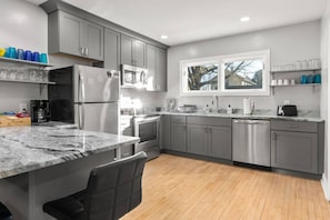 A modern kitchen with grey cabinets, stainless steel appliances, and a marble countertop. - A Fresh, Modern Home * Great Locale Near Downtown Appleton (Appleton)