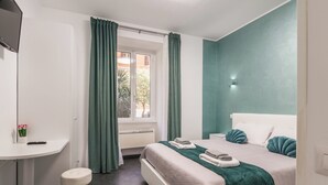 Un dormitorio con cama, escritorio y ventana con cortinas.