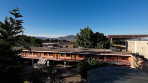 Un hotel con tetto piatto, diverse camere e vista sulle montagne.