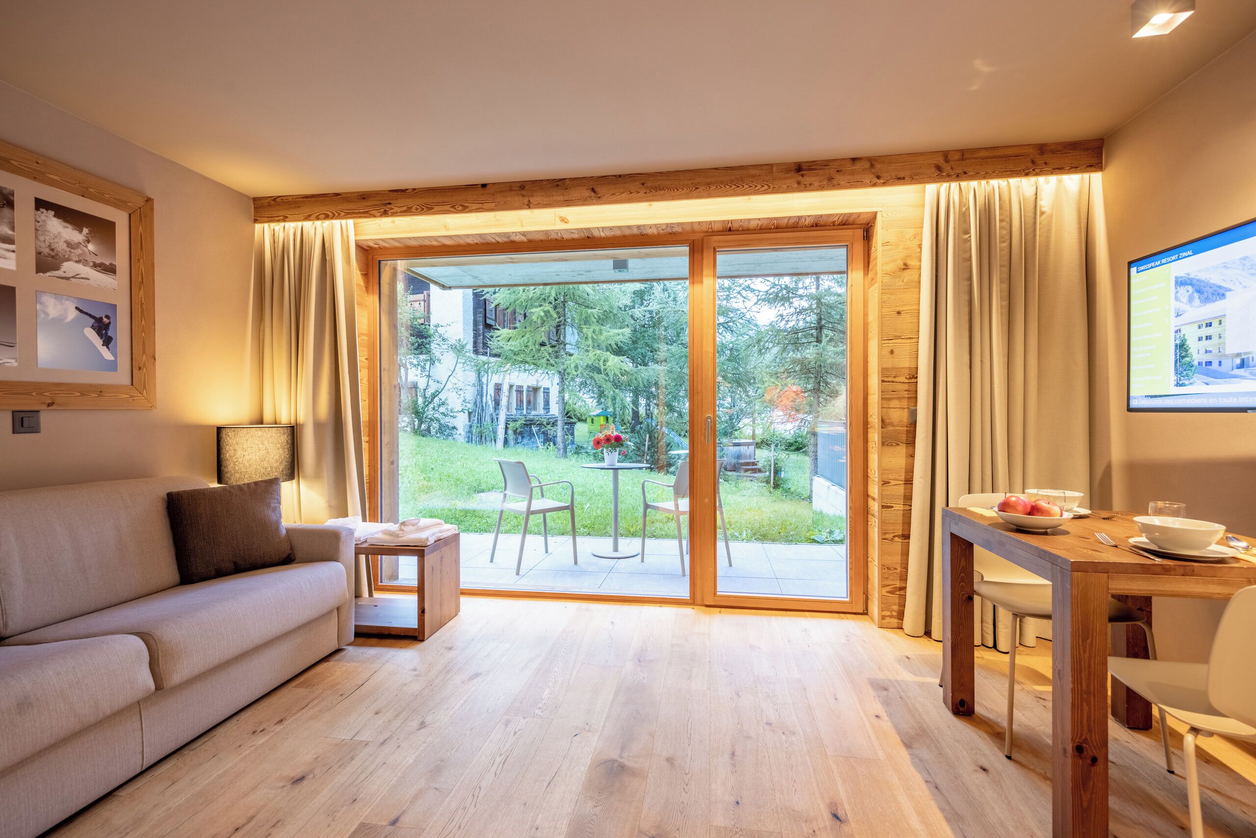 Una sala de estar moderna con un sofá, una mesita y un comedor con una mesa de madera y sillas.