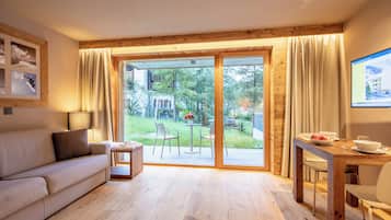 Una sala de estar moderna con un sofá, una mesita y un comedor con una mesa de madera y sillas.