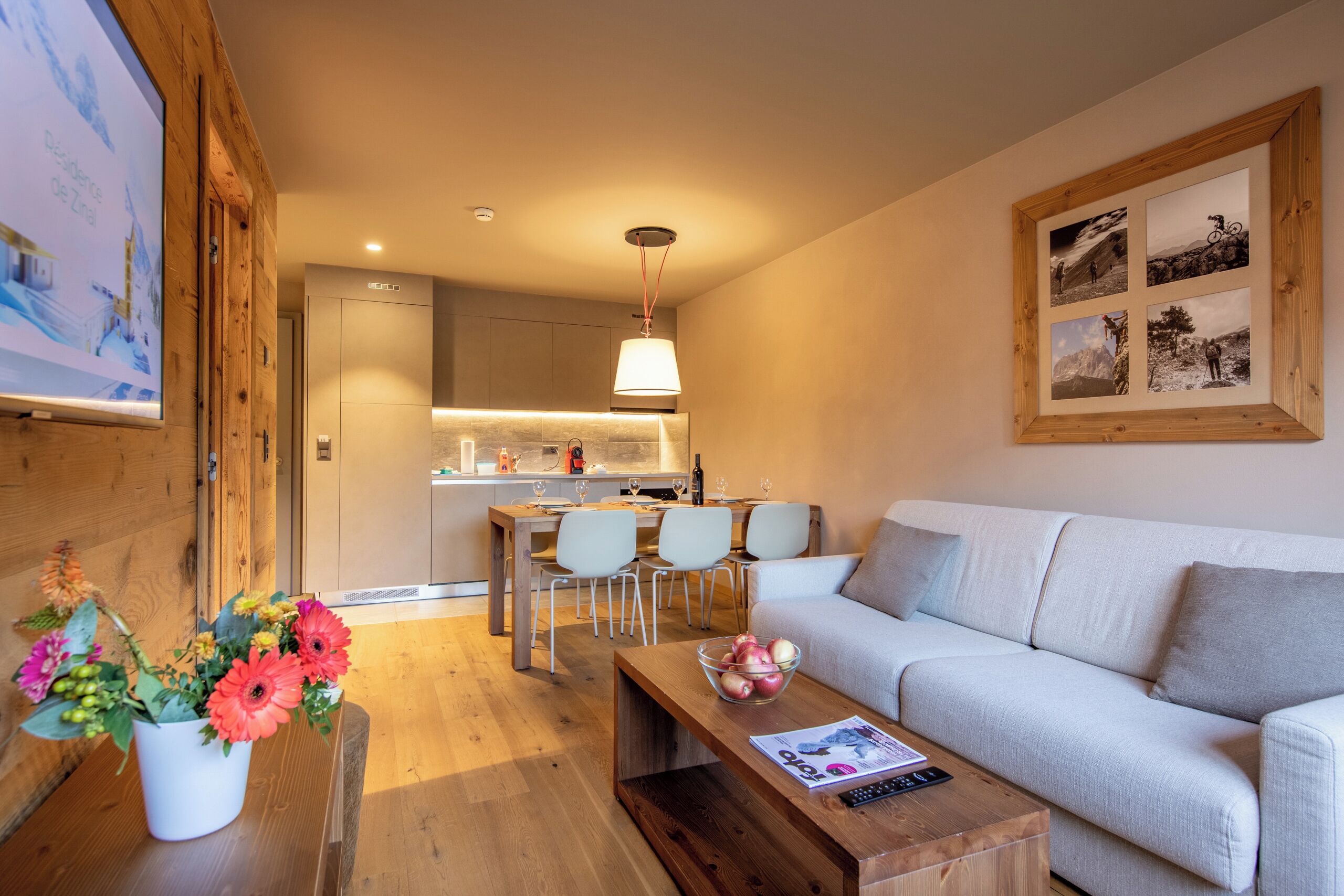 A modern living room with a sofa, a coffee table, and a dining area with chairs.