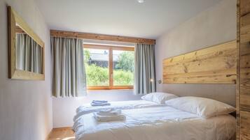 Un dormitorio con cama, cortinas, cabecero de madera y ventana.