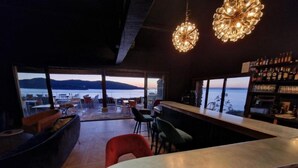 Zona de bar moderna con vistas a un lago y montañas.