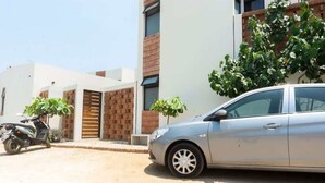 A modern building with a car parked in front. - Casa Aymara 601: Beach, Starlink & Privacy (Brisas de Zicatela)