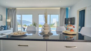 Un hotel moderno con una ventana grande que ofrece vistas al mar y a las montañas.