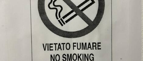 A no-smoking sign with text in multiple languages.
