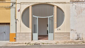A building entrance with a large circular window and metal gates.