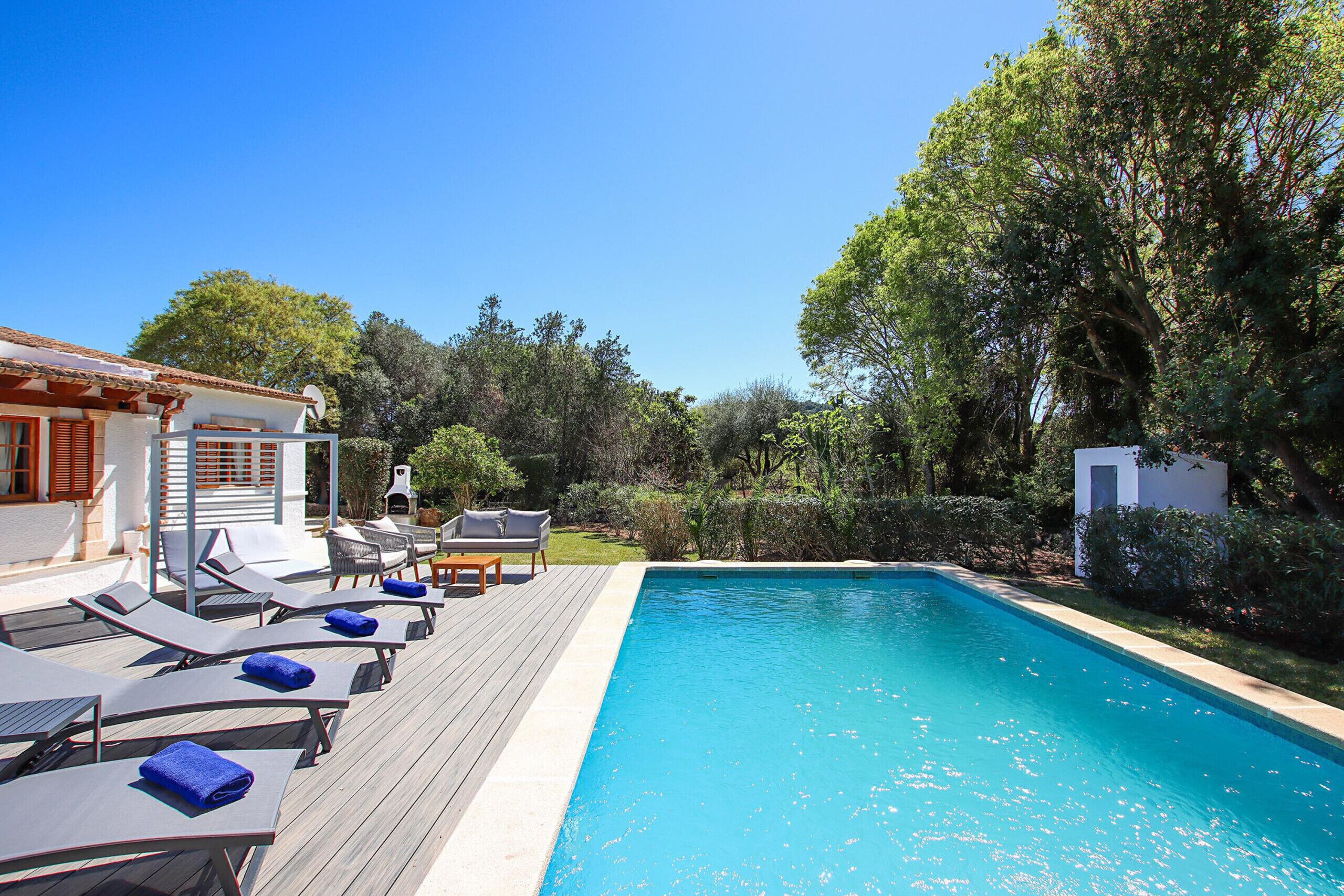 Piscina com espreguiçadeiras e um pérgola.